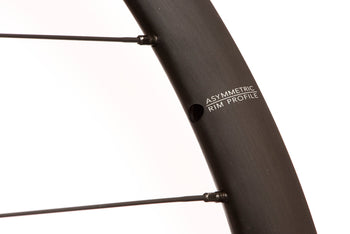 <h1>Rims</h1><i>A strong and lightweight 6061-T6 heat-treated rim features an asymmetric shape which is inverted from front to rear to provide balanced higher spoke tensions meaning your spokes stay tight for the long term. The rim profile is disc specific which allows higher-strength to weight as no reinforcement is required for a braking surface. The extra wide rim at 25mm (20mm internal) which creates a great tyre profile with wider 25-50mm tyres, giving excellent grip and lower rolling resistance.</i>